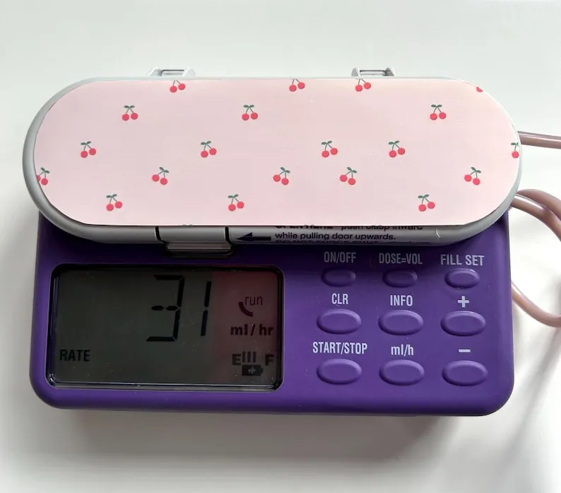 A feeding pump with a pink cherry-print sticker on the top — the first design Siena made, for her own pump.